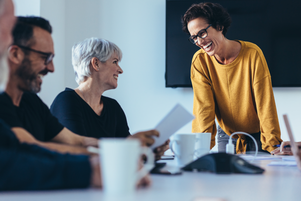 Photo of a group of people in a meeting room smiling